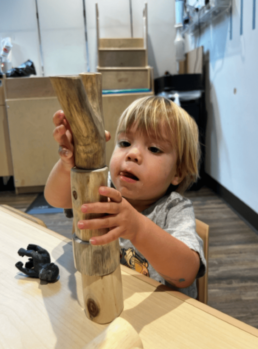 Toddler building a tower with colorful blocks.