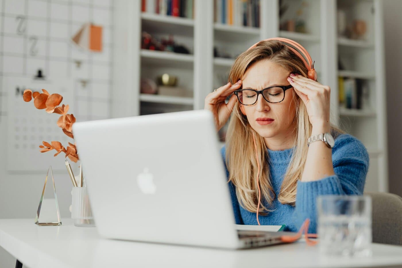 A woman meditating at her work desk, symbolizing mental health resources and workplace wellness