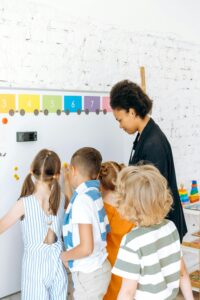 A-Teacher-Standing-In-Front-Of-A-Whiteboard-With-Her-Students