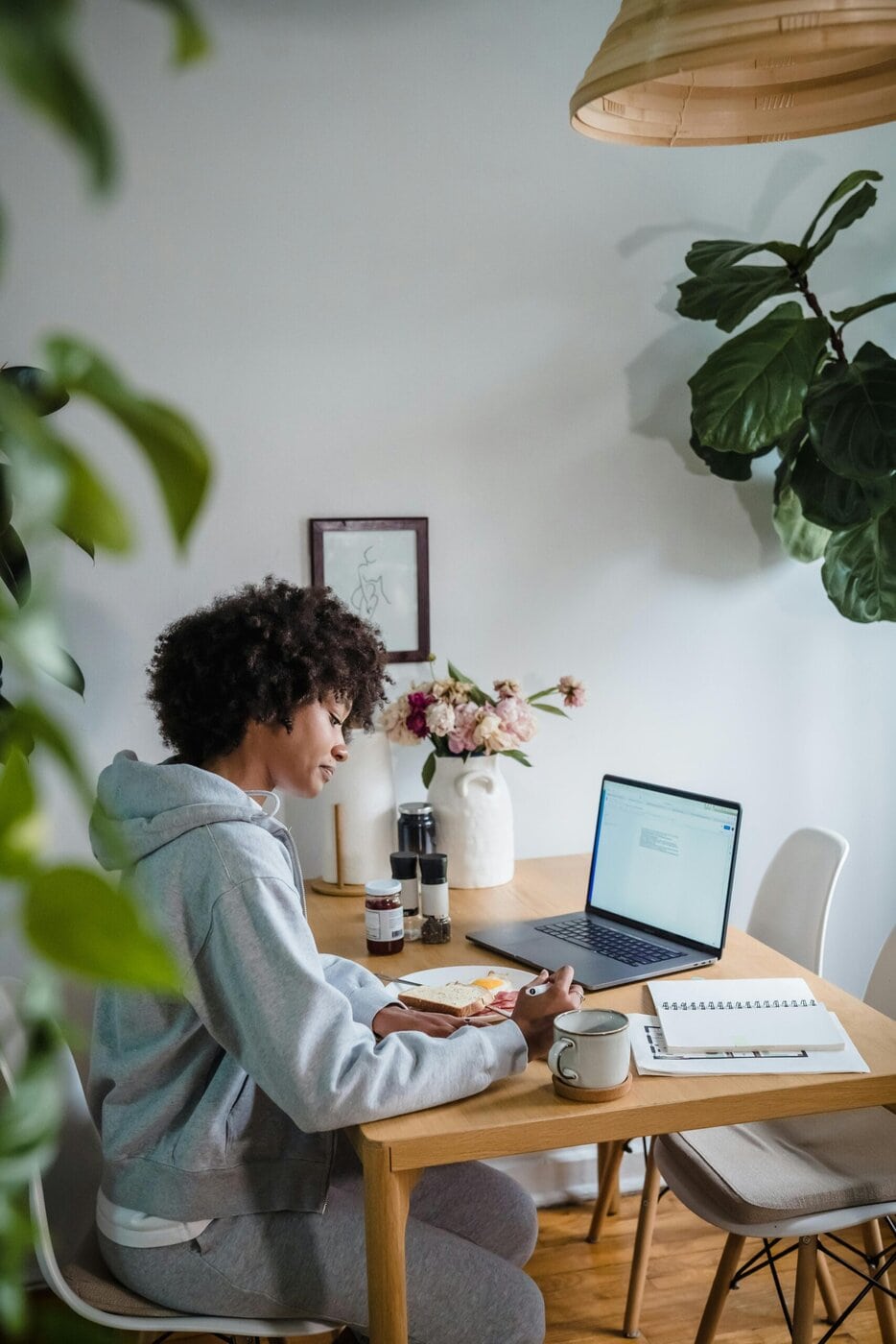 woman-eating-breakfast-and-working-remotely